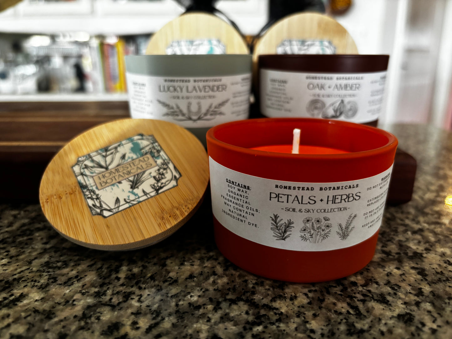 Candle with a wooden lid on a countertop, surrounded by other candles.